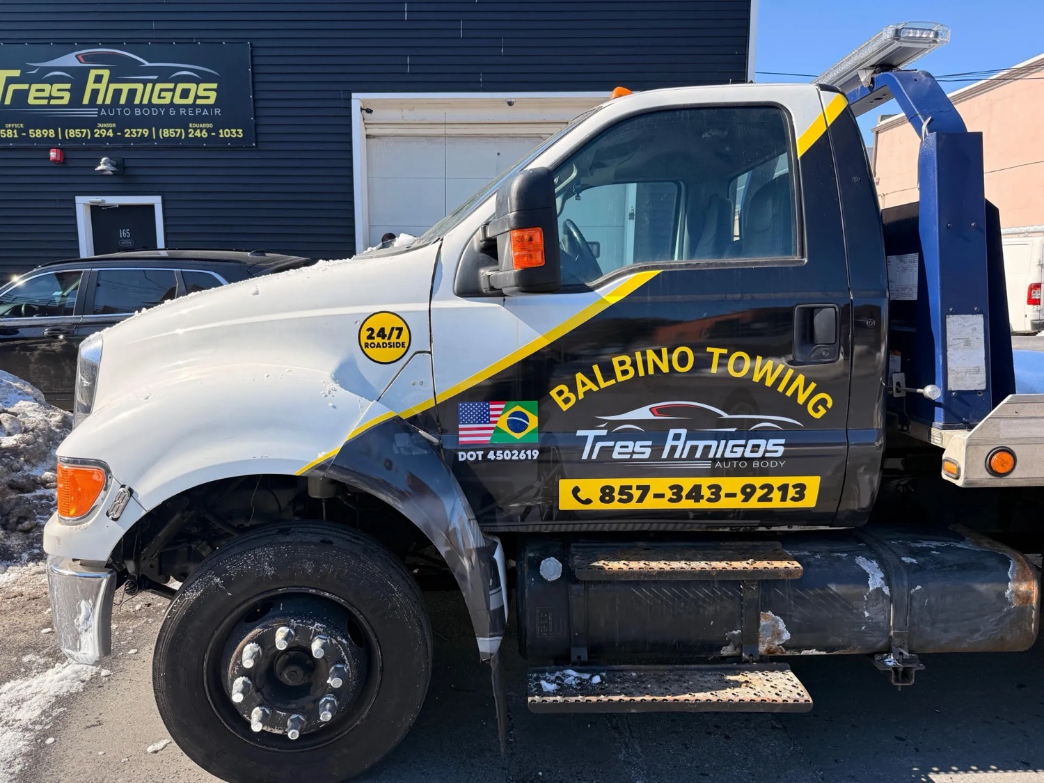 Tres Amigos Auto Body's own tow truck parked at the shop, ready for 24-hour towing